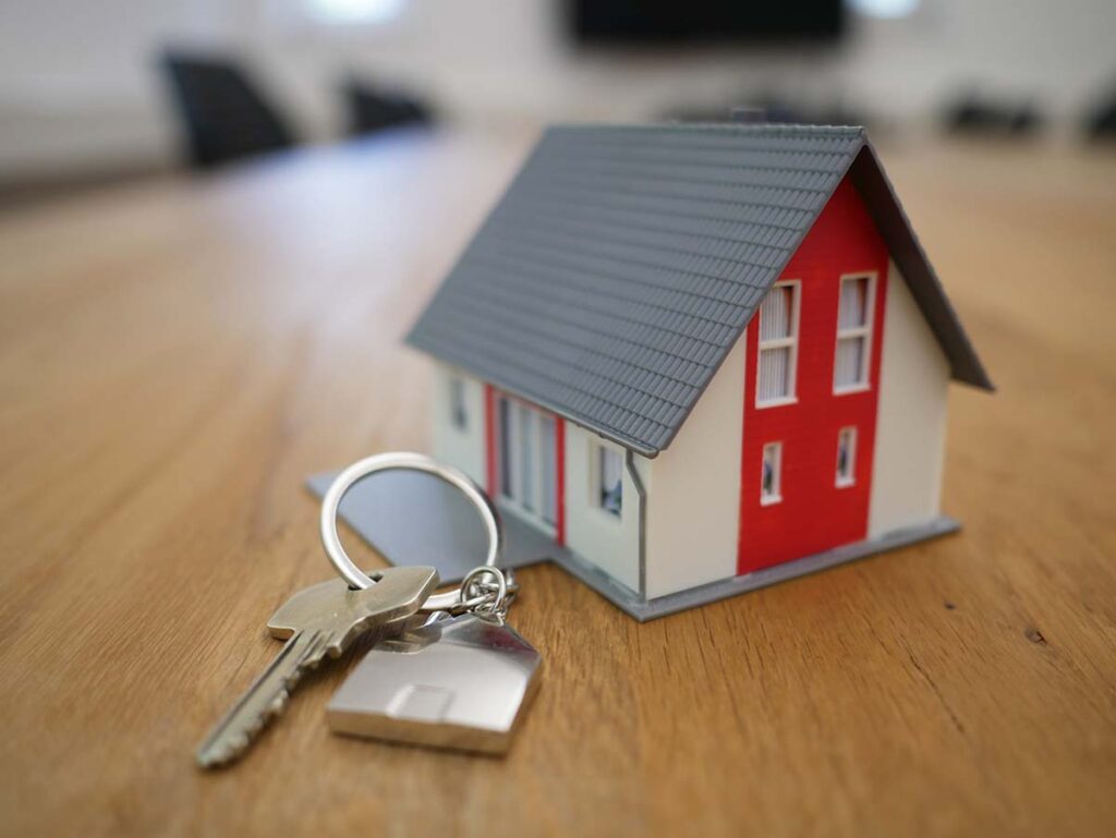 mini house on a table with a key next to it